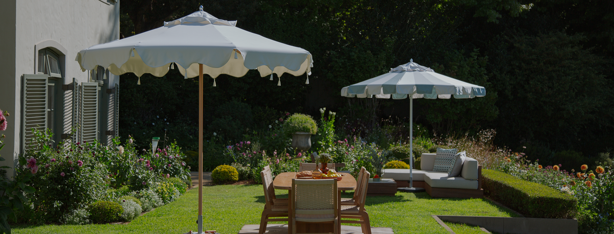 Garden dining table under pale Cape Umbrellas