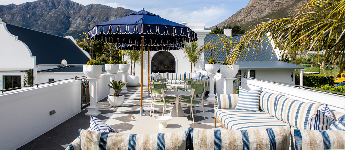 Terrace with a navy Cape Umbrella and mountains behind